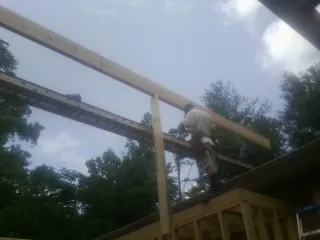 Carpenter setting a ridge beam over a new addition frame — Ice Dam Removal by Roofing Brothers in Bolivia
