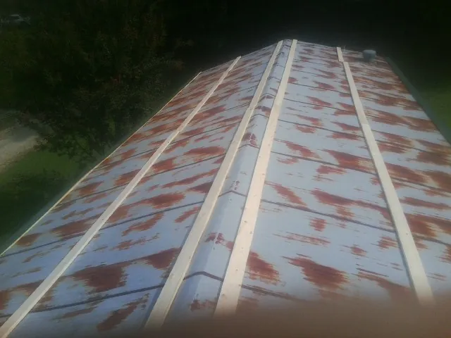 Rusted metal roof panels with new wood purlins before replacement — Storm Damage Roof Repair in Bolivia by Roofing Brothers