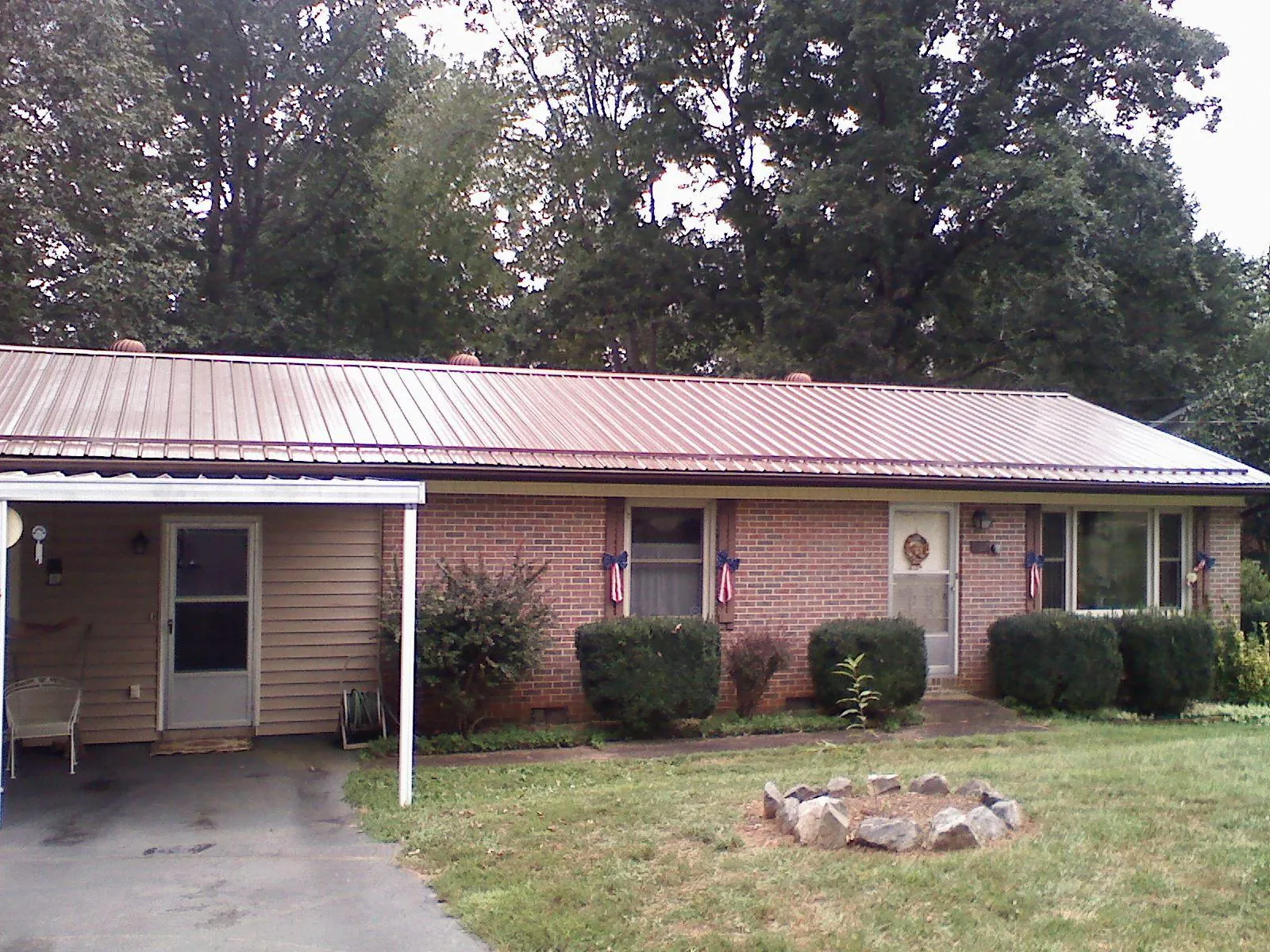 Bronze metal roof and carport on a brick ranch home — Roof Repair work by our crew in Bolivia